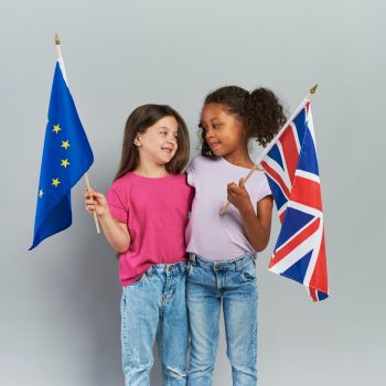 girls-embracing-holding-british-european-union-flags